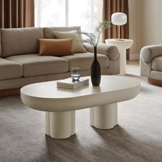 a living room filled with furniture and a vase on top of a table in front of a window