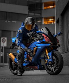 a man riding on the back of a blue motorcycle