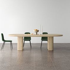 a table with two green chairs and a bowl of fruit on the dining room table