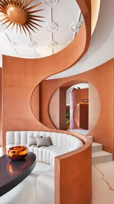 a living room filled with white couches and a circular mirror on the wall above it