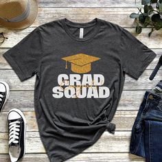 Graduation Squad Shirt, Graduate Shirt, Squad Shirt, Grad Squad Shirt, Proud Family Of The Graduate, Congrats Shirt, Graduation Shirt 2023! Everyone needs the perfect t-shirt to complement an everyday, laid-back look. The ideal top for so many occasions, this lightweight cotton tee will keep you comfy and looking smart. * 100% combed and ring-spun cotton (Heather colors contain polyester) * Fabric weight: 4.2 oz/yd² (142 g/m²) * Pre-shrunk fabric * Side-seamed construction * Shoulder-to-shoulder Grad Squad Shirt Ideas, Casual Graduation Shirt With Text Print, Short Sleeve Shirt With Text Print For Graduation, Casual Shirt With Text Print For Graduation, Cotton Graphic Print Shirt For Graduation, Casual Cotton Tops For Graduation, Cotton Crew Neck Top For Graduation, Casual Short Sleeve Tops For Graduation, School Spirit Tops For College Graduation