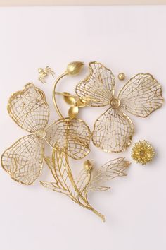 gold plated metal flowers and leaves on a white background