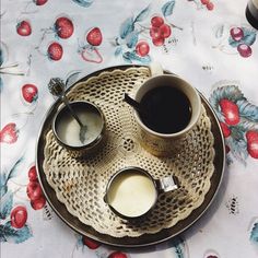 two cups of coffee on a plate with spoons