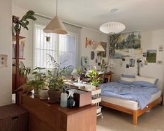 a bed room with a neatly made bed and lots of plants