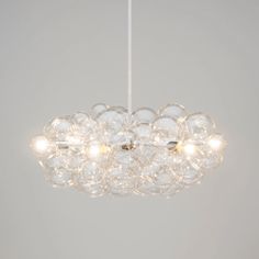 a chandelier hanging from the ceiling with clear glass balls on it's sides