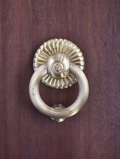 a door handle on a wooden door with a circular design in the middle and center