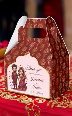 a red and gold wedding favors box on a table