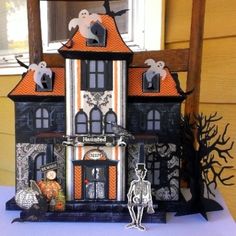 a halloween house with decorations on the front and side of it, in front of a window