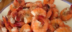 a white plate topped with lots of cooked shrimp