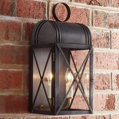 an outdoor light on the side of a brick wall with two lights attached to it