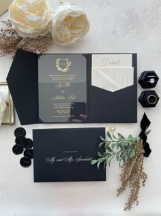 the wedding stationery is laid out on top of each other with flowers and greenery