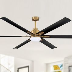 a ceiling fan in a living room with white walls and black blades hanging from the ceiling