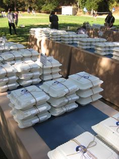 there are many trays on the table ready to be served at an outdoor event