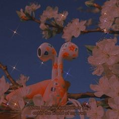 an orange toy sitting on top of a tree filled with flowers