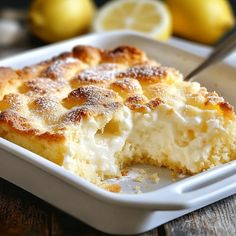 a close up of a piece of cake in a pan with lemons behind it