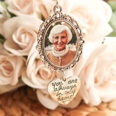 a necklace with an image of queen elizabeth on it and flowers in the back ground