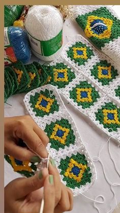 a woman is working on some crocheted items with yarn and thread in front of her