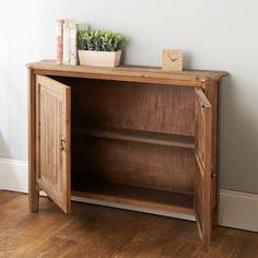 a wooden cabinet with a plant on top