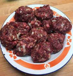 a white plate topped with meatballs on top of a wooden table