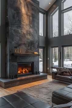 a living room filled with furniture and a fire place in front of a large window