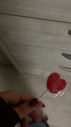 a person holding a lollipop with a heart on it