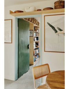 an open door leading to a room with bookshelves and pictures on the wall