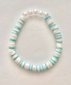 This teal and white stretch bracelet with pearls fits up to a 6.5" wrist. A great gift for a special girl! Teal Clay Bead Bracelet, Clay Beads Design Ideas, Clay Bead Bracelet Inspo Aesthetic, White Round Beads Stretch Bracelet For Birthday, Playful White Stretch Bracelet For Birthday, Handmade White Pearl Bracelet For Birthday, Playful White Stretch Bracelet With Round Beads, White Hypoallergenic Pearl Bracelet For Birthday, Adjustable White Pearl Bracelet For Birthday