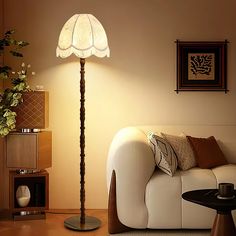 a living room scene with focus on the floor lamp and couch in the foreground