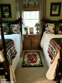 two beds in a bedroom with christmas decorations on the headboard and foot board, along with a rug