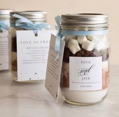 three jars filled with marshmallows on top of a table