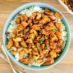 a bowl filled with chicken and rice on top of a wooden table