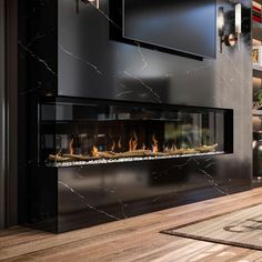 a modern fireplace in the middle of a living room with wood flooring and black walls