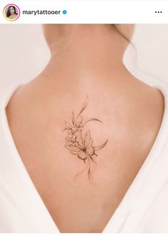 a woman's back with a flower tattoo on it