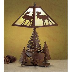 a lamp that is sitting on top of a table next to a pine tree and moose