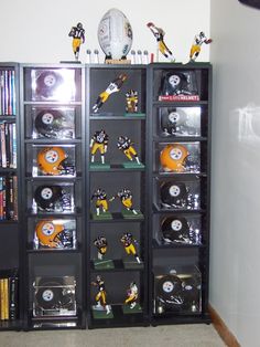 a bookcase filled with football memorabilia on top of a carpeted floor