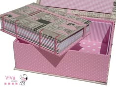 a pink and white polka dot box with many papers in it's bottom compartment