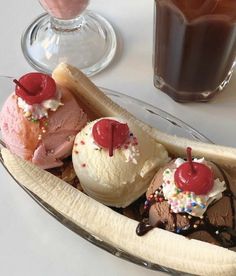 three ice cream sundaes in a banana split with chocolate syrup and cherries