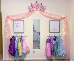 there is a room with princess dresses hanging on the wall and lights strung from the ceiling