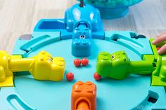 a child's hand is playing with toys on the table