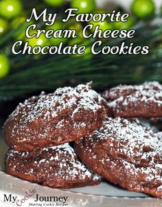 chocolate cookies with powdered sugar on top and green christmas decorations in the background text reads, my favorite cream cheese chocolate cookies