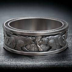 a ring with elephants on it sitting on top of a piece of cloth in front of a black background