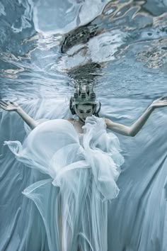 a woman in white dress floating under water