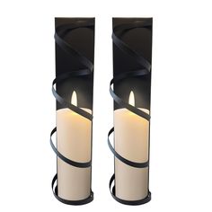 two black and white vases with lit candles in the middle, one on each side