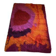 an orange and purple rug on a white background with no one in the photo looking at it