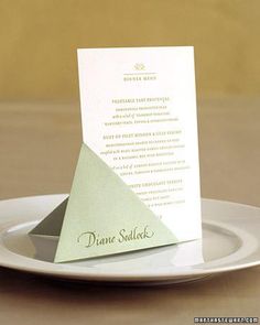 a white plate topped with a piece of paper on top of a menu card holder