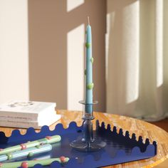 a blue candle holder sitting on top of a wooden table