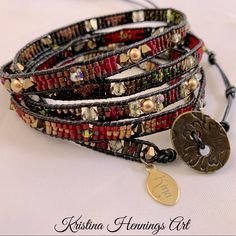 the bracelet is decorated with beads and metal charms, which are attached to leather cords