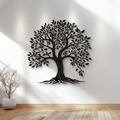 a large metal tree wall hanging on the side of a white wall in an empty room