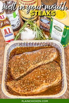 some meat is in a pan with sauce and seasonings on the table next to it