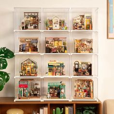 a shelf filled with lots of toy houses on top of wooden shelves next to a potted plant